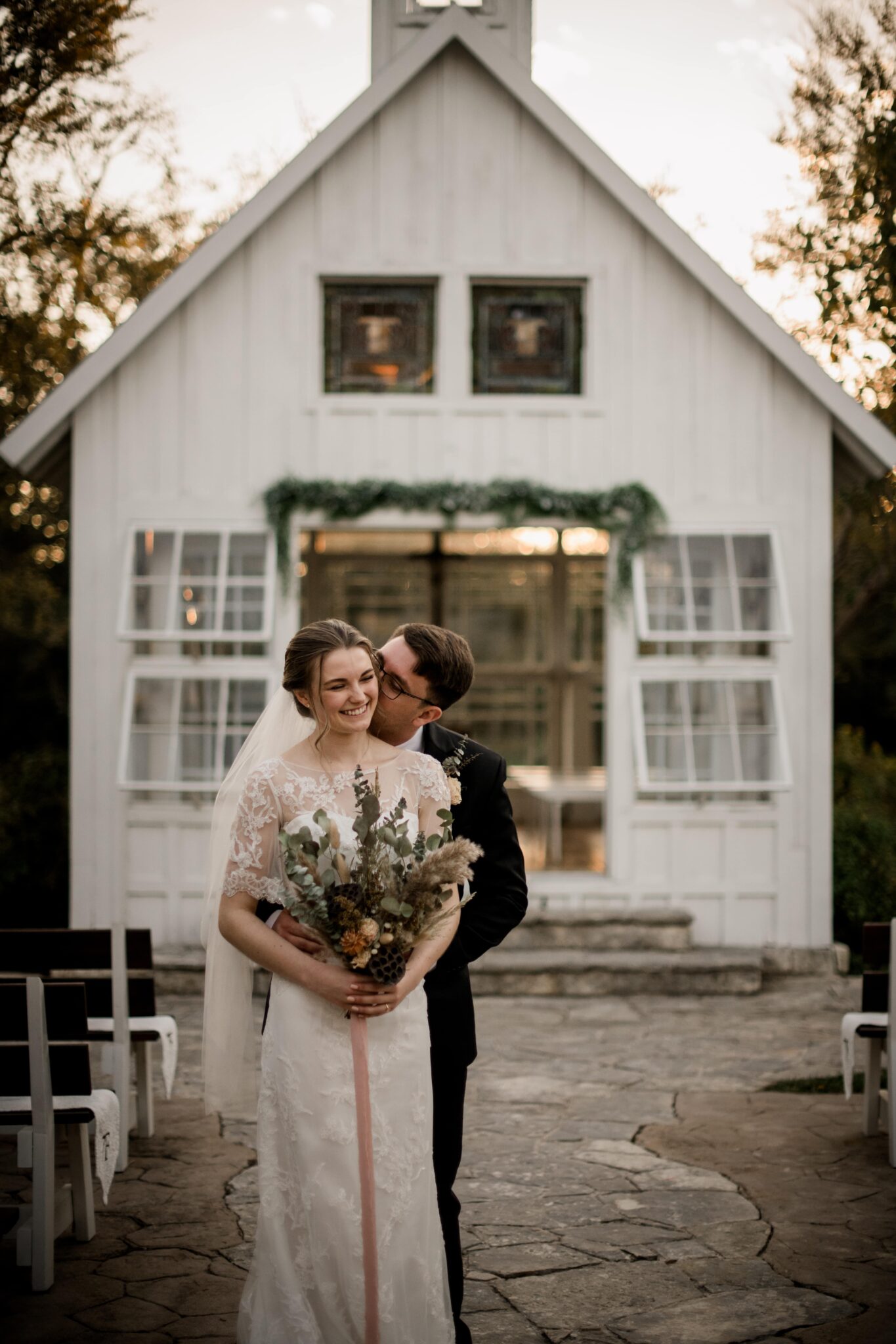 the texas bride and groom are posing for couple photos in front of the 7F Lodge wedding venue