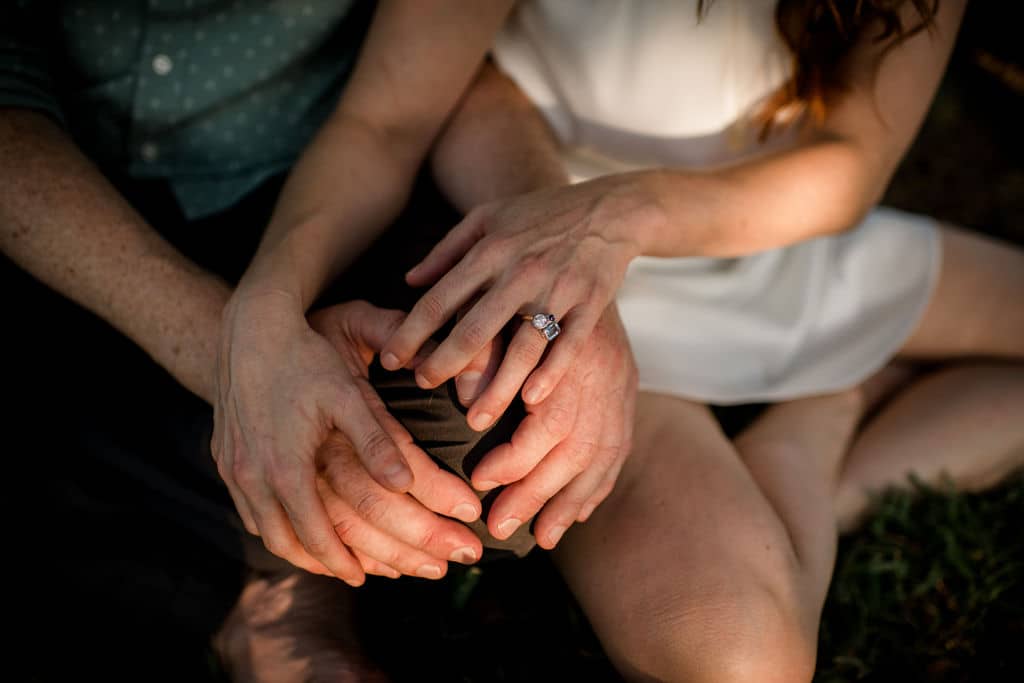 the texas newlyweds sit in their backyard lawn intertwining their hands