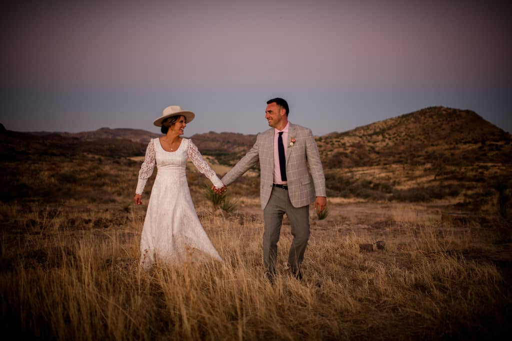 the bride and groom walk through texas's big bend national park