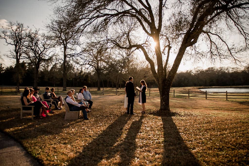 the texas bride and groom share their vows by a tree at their intimate airbnb elopement