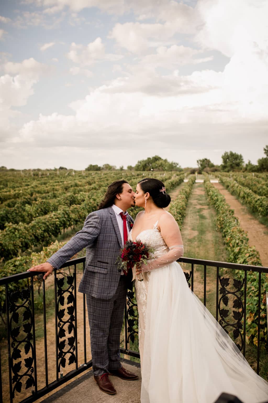 the bride and groom share a kiss overlooking texas's messina hof winery
