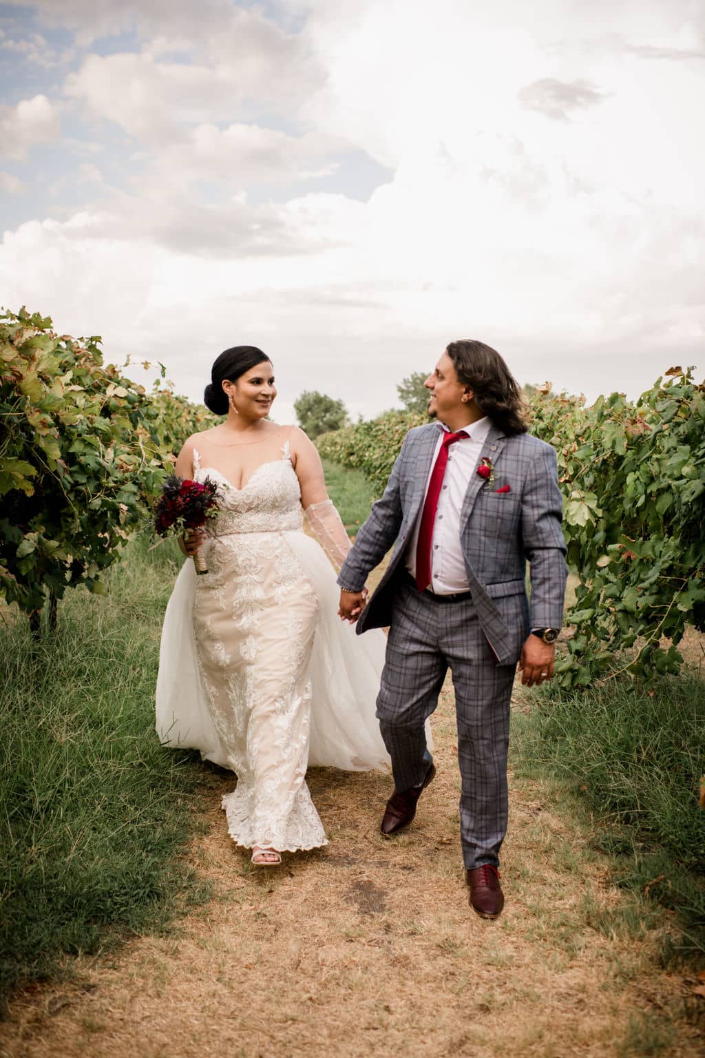 the neylwed bride and groom walk through the messina hof winery is texas