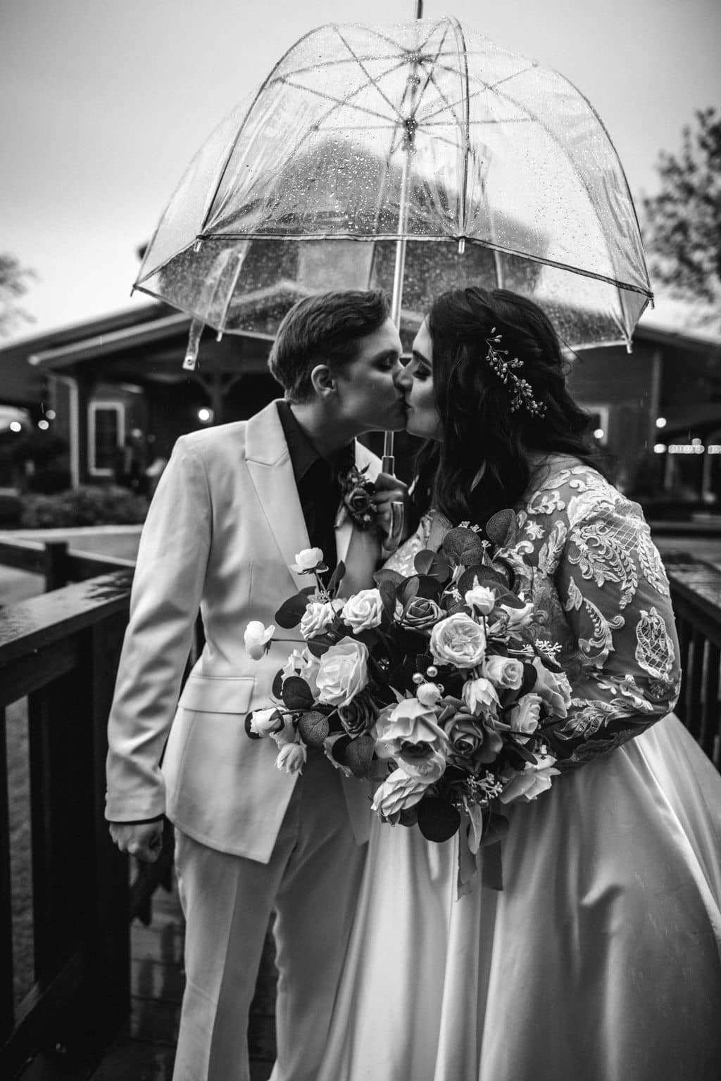 two brides kissing under the umbrella at a bryan-college station wedding venue in an inclusive client experience