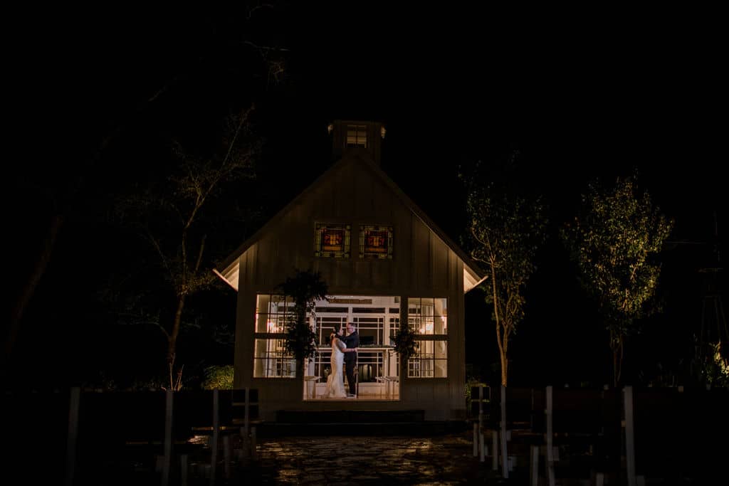 bride and groom dancing in the night inside the white chapel of 7F Lodge