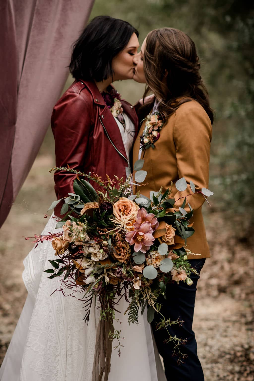 two brides stand at the alter of their wedding day surrounded by florals by a texas wedding florist