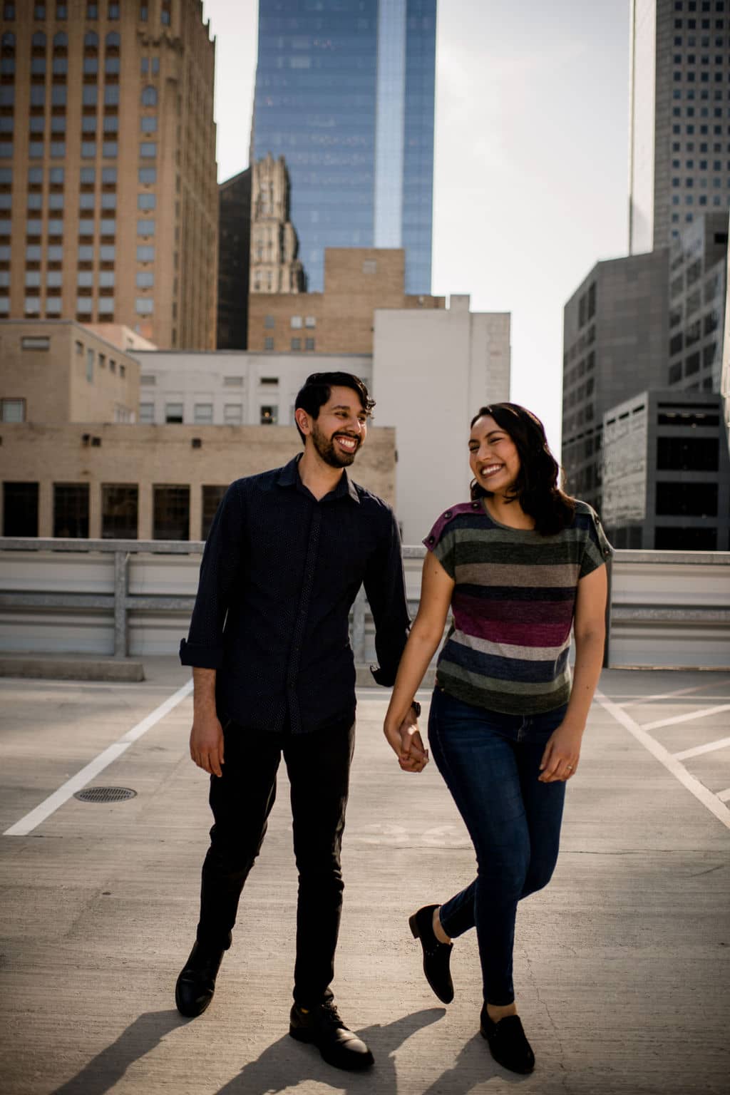 the future bride and groom are in golden hour on a texas rooftop