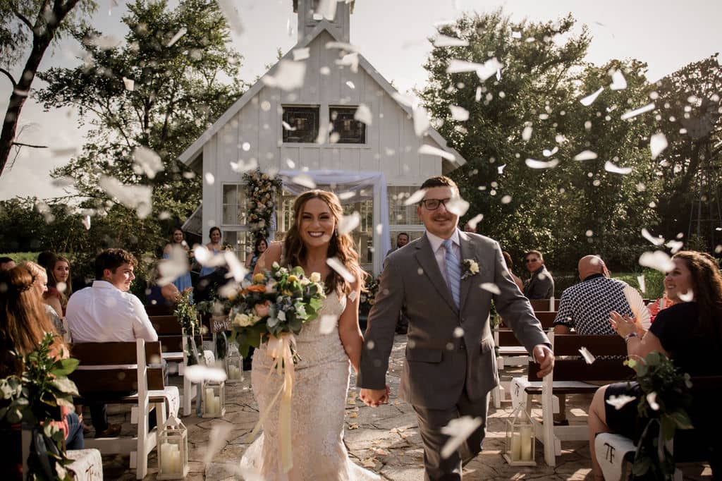 the bride and groom exiting their texas summer wedding with eco-friendly confetti