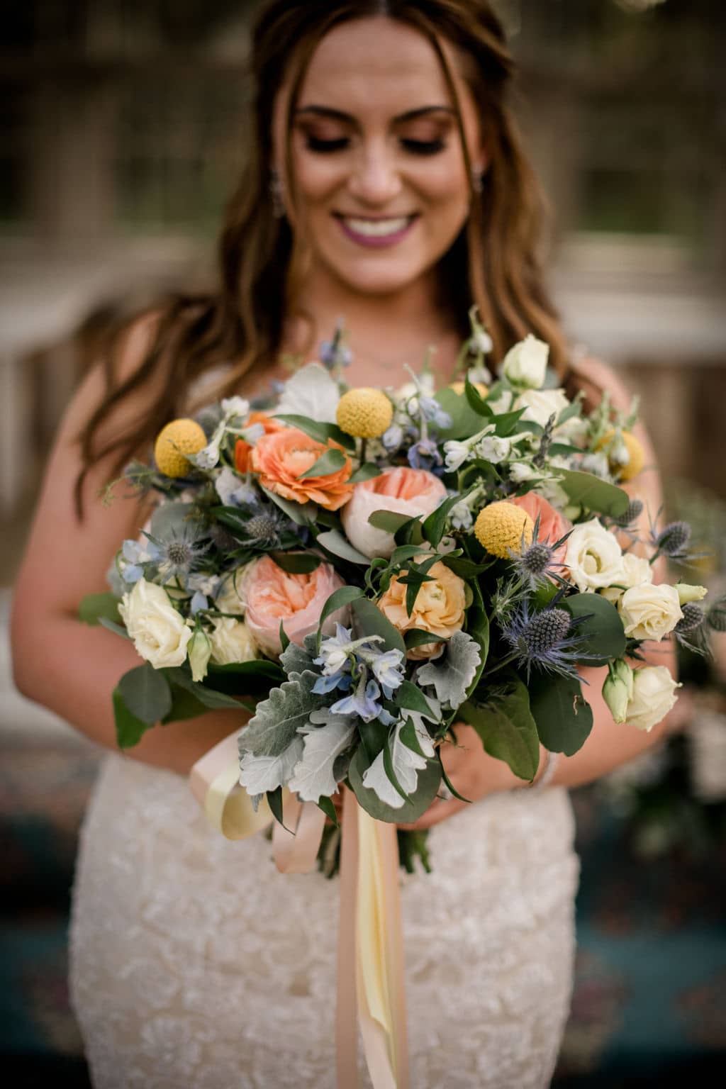the texas bride is holding her summer seasonal floral bouquet