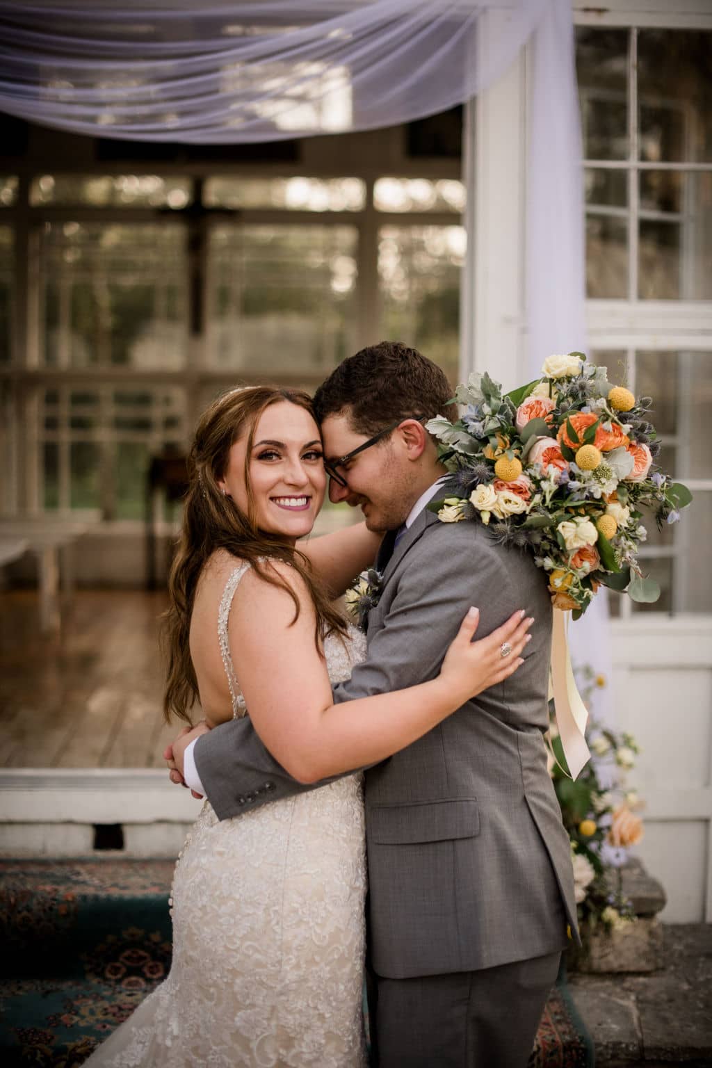 the texas bride and groom are embracing each other while the groom stares into the bride