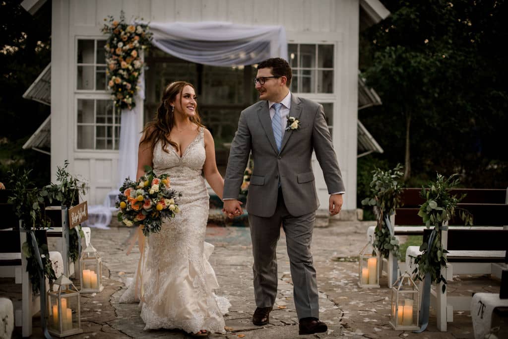 the texas bride and groom walk down the aisle after their texas summer wedding