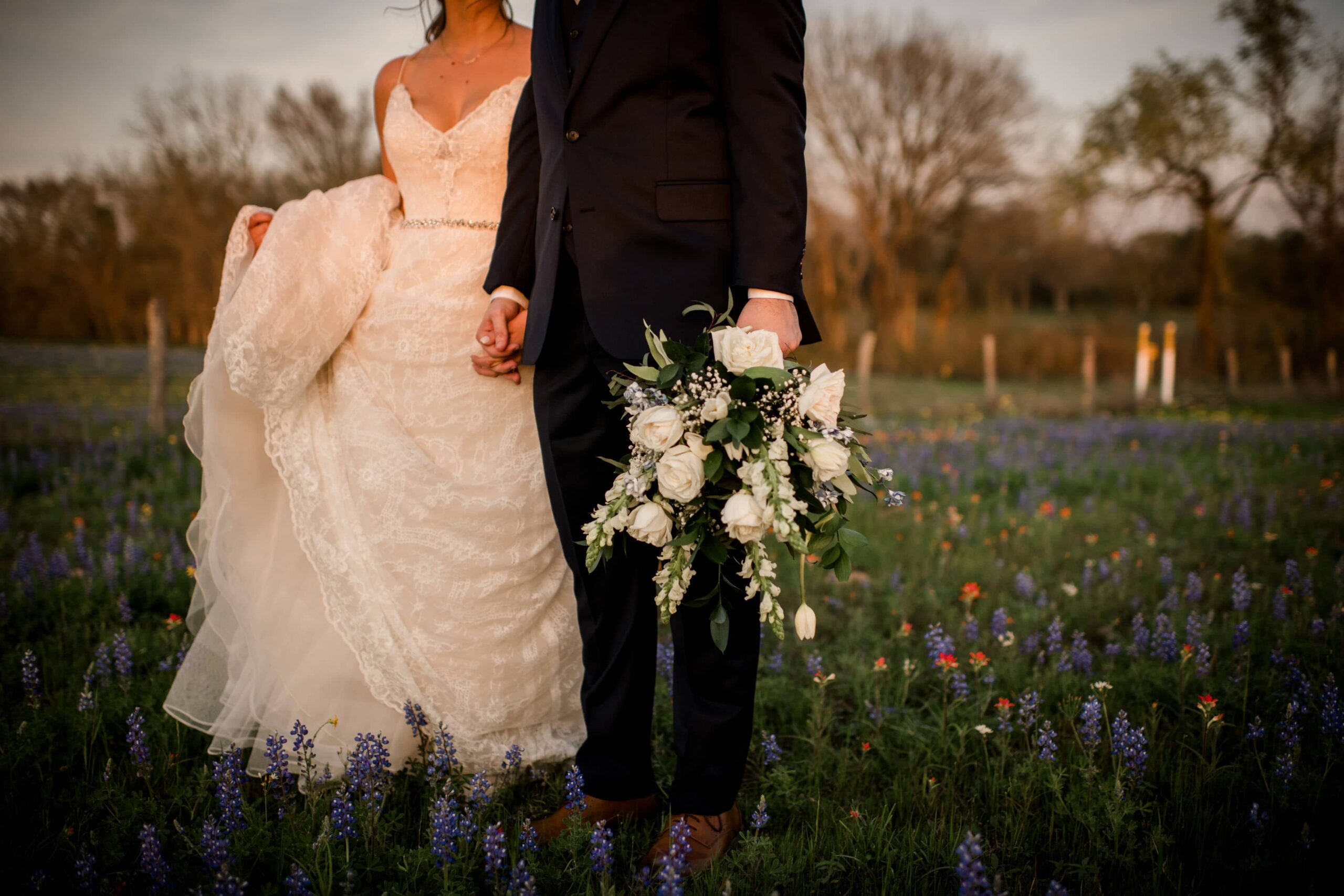 Bride and groom walking in a field in bryan college station texas after their wedding.