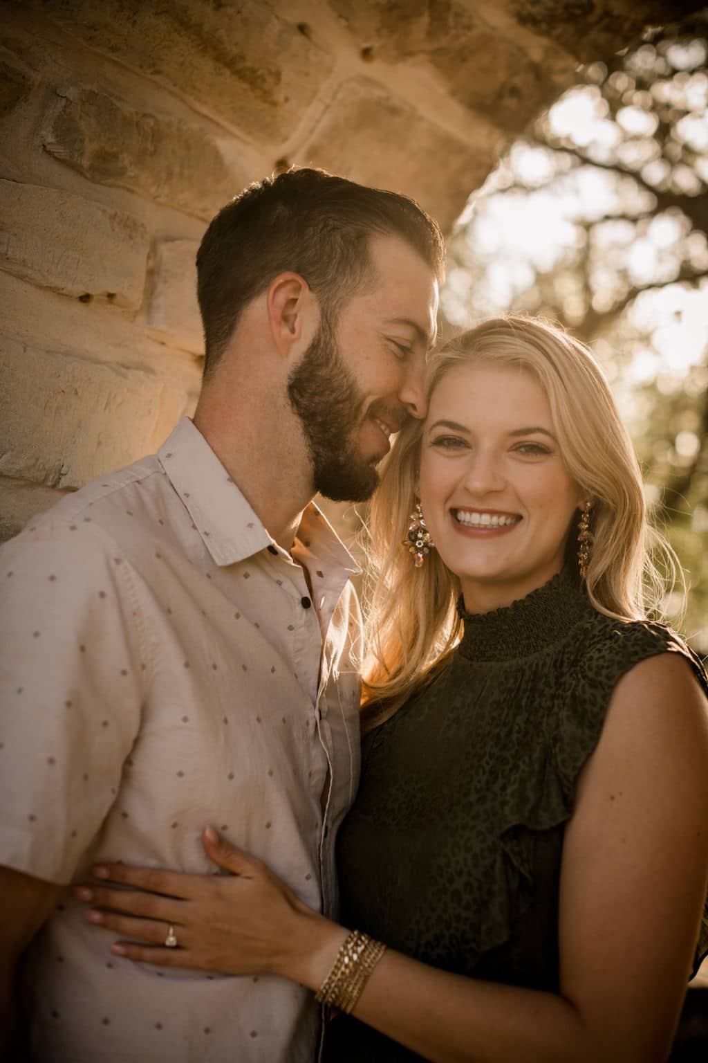 the future bride and groom are smiling under golden hour