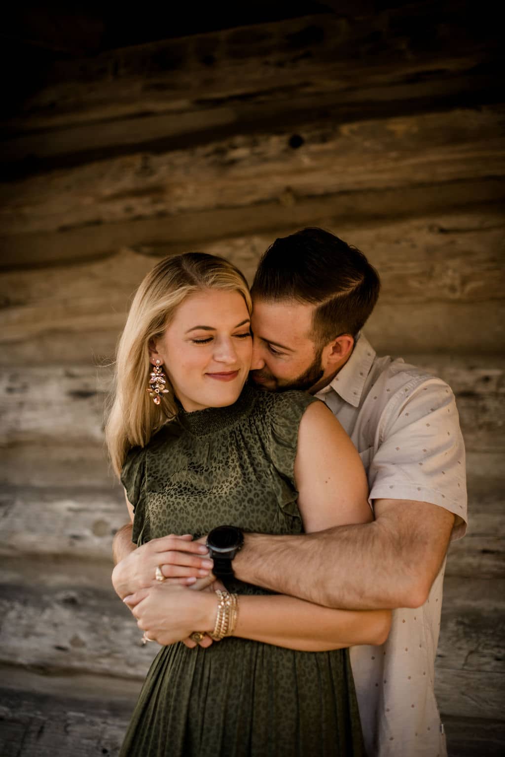 the future groom is hugging his future bride from behind