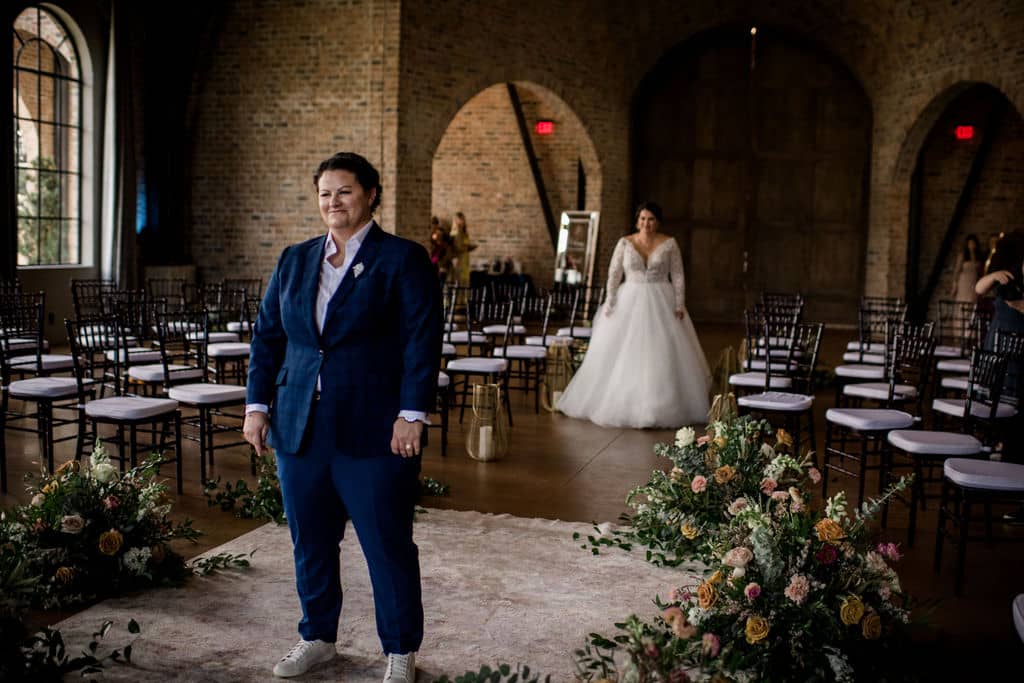 two brides stand at the alter of their wedding day surrounded by florals by a texas wedding florist