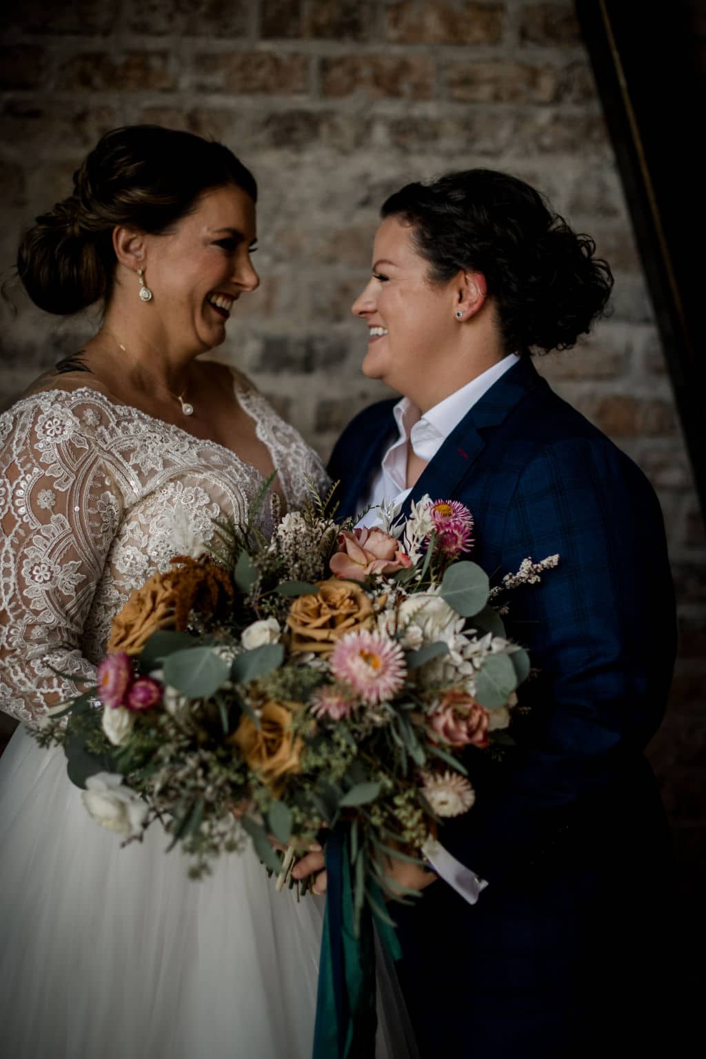 the texas bride and groom are standing behind an intricate bouquet done by urban rubbish