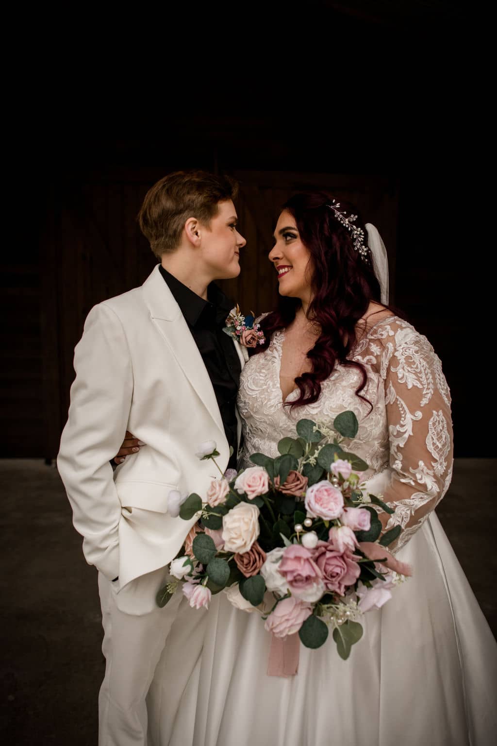 the texas brides both dressed in white share a smile together