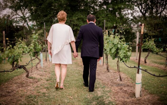 husband and wife walk the texas vineyards after their vow renewal ceremony