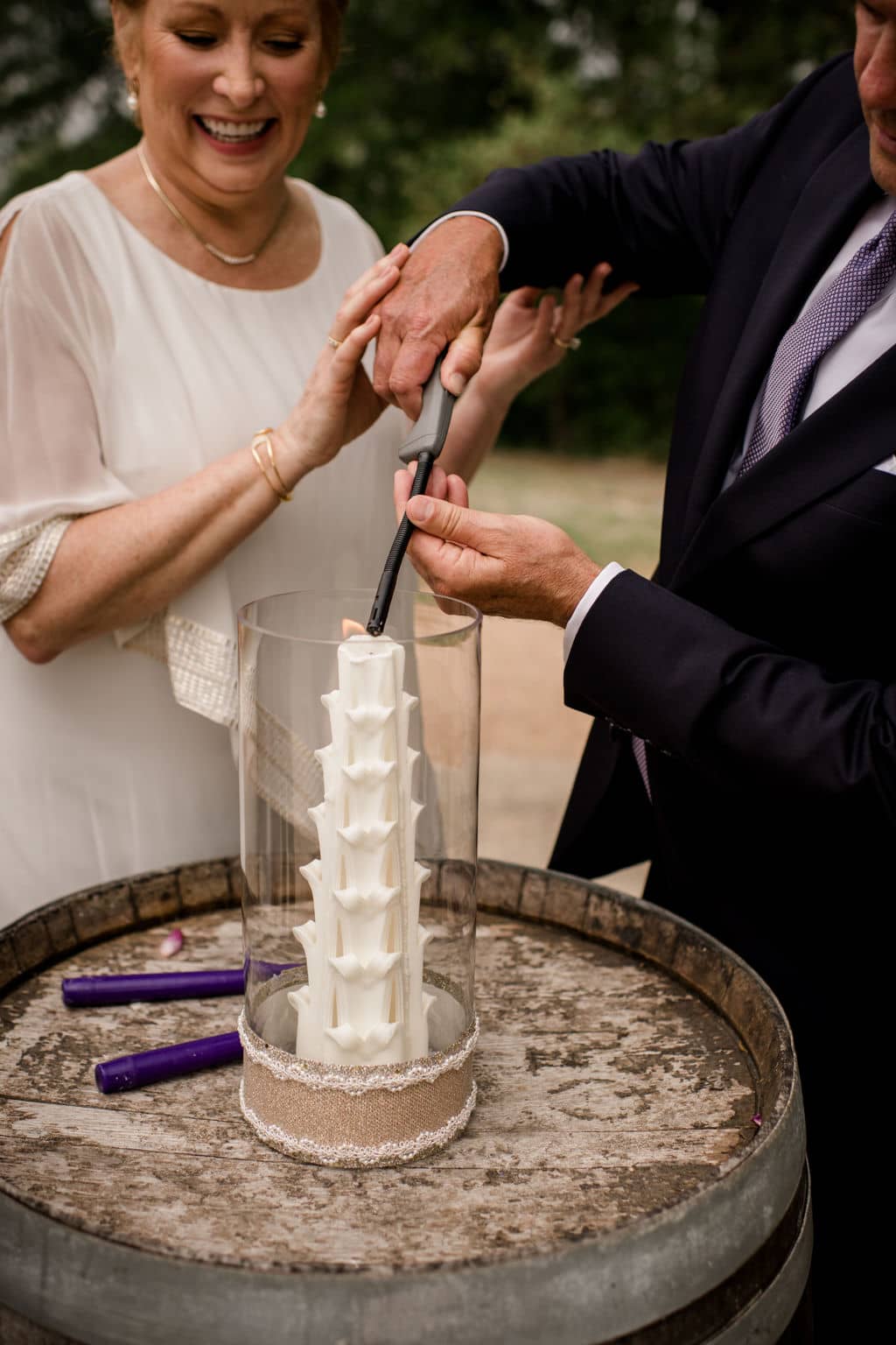 the husband and wife light a candle for their vow renewal