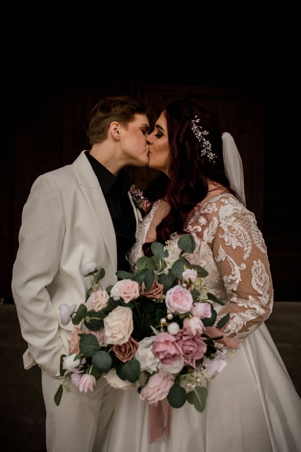 the two texas brides share a kiss before their wedding both dressed in white